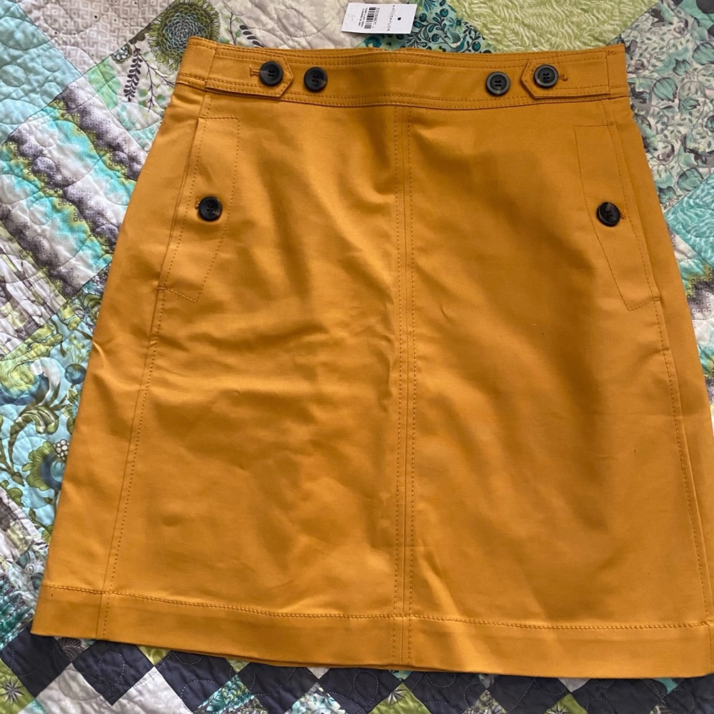 Ann Taylor skirt, dark yellow, size 6, with black buttons. New with tags. Cute!